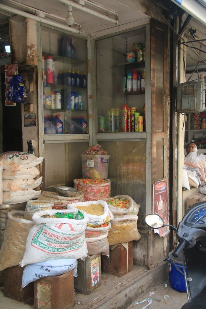 A grocery storefront stocked with sacks of grain and festival supplies